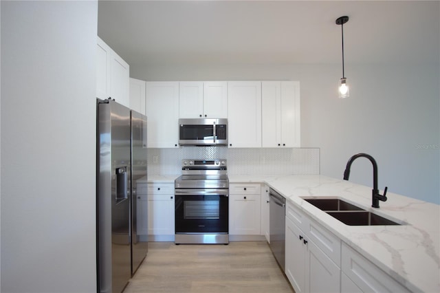 6779 David Blvd, Port Charlotte, FL 33981 - kitchen with appliances with stainless steel finishes, backsplash, white cabinetry, light wood-style flooring, and light stone counters