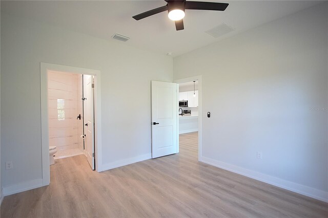 6779 David Blvd, Port Charlotte, FL 33981 - unfurnished bedroom featuring light wood-style flooring, connected bathroom, and ceiling fan