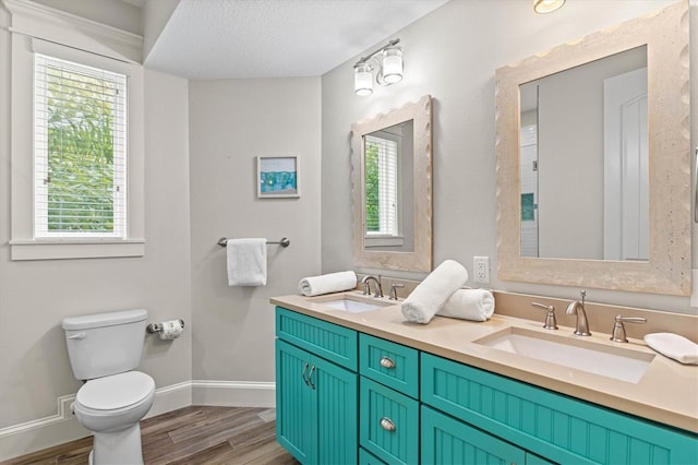 bathroom featuring vanity, wood-type flooring, a textured ceiling, and toilet