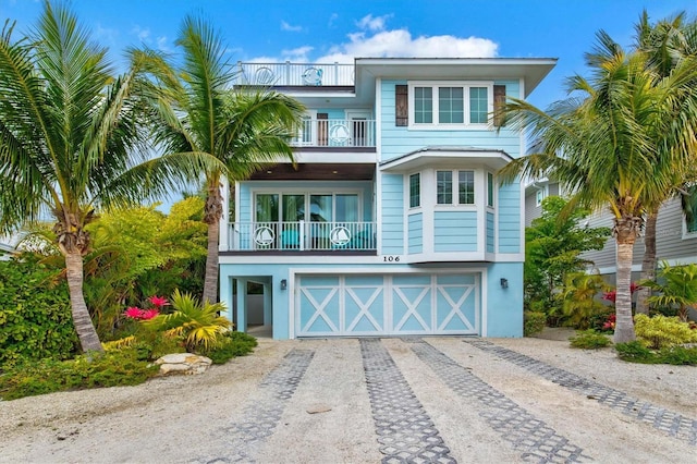 raised beach house with a balcony and a garage