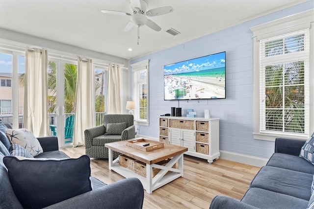 living room featuring ceiling fan and light hardwood / wood-style floors