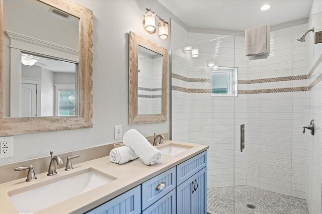 bathroom featuring ceiling fan, a shower with door, and vanity