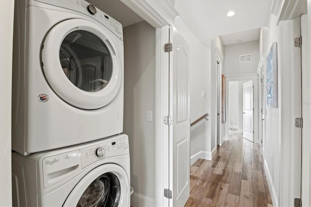 washroom featuring light hardwood / wood-style floors and stacked washer and clothes dryer