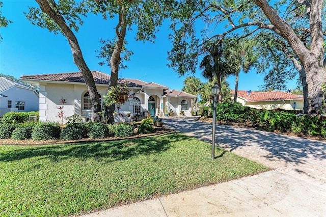 mediterranean / spanish-style house featuring a front yard