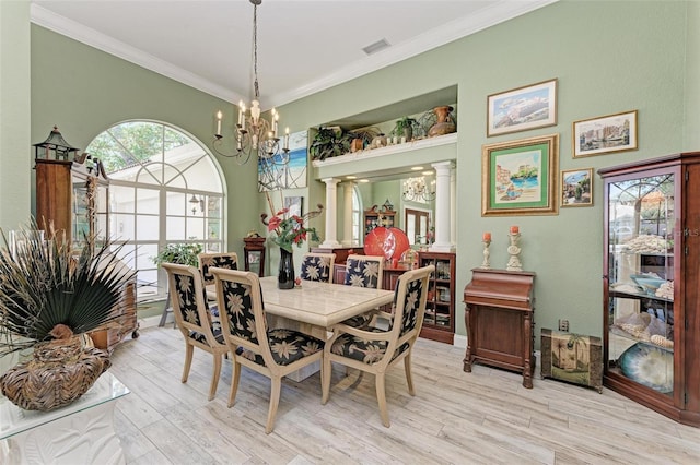 dining area with decorative columns, light hardwood / wood-style flooring, crown molding, and a notable chandelier