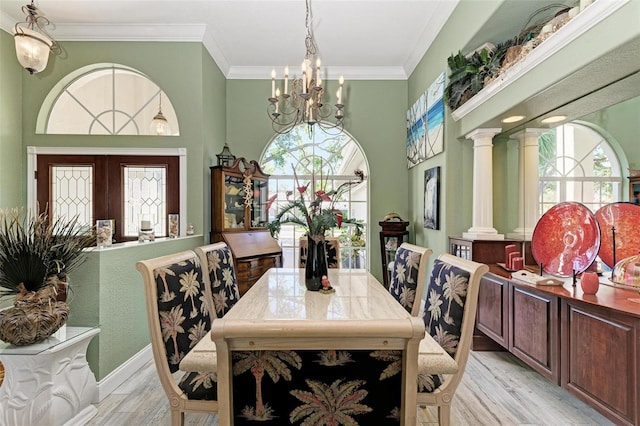 dining space with a healthy amount of sunlight, decorative columns, and light hardwood / wood-style floors