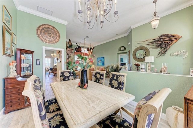 dining space with a chandelier, crown molding, and light hardwood / wood-style flooring