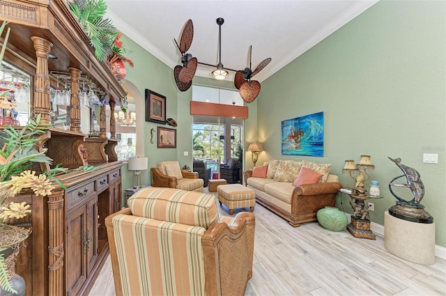 living room with light wood-type flooring, ceiling fan, and ornamental molding