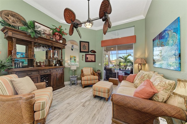 living room featuring ceiling fan, light hardwood / wood-style floors, and crown molding