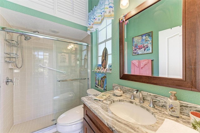 bathroom featuring vanity, toilet, and a shower with shower door