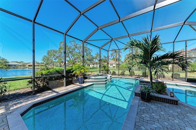 view of pool with an in ground hot tub, a patio, a water view, and glass enclosure