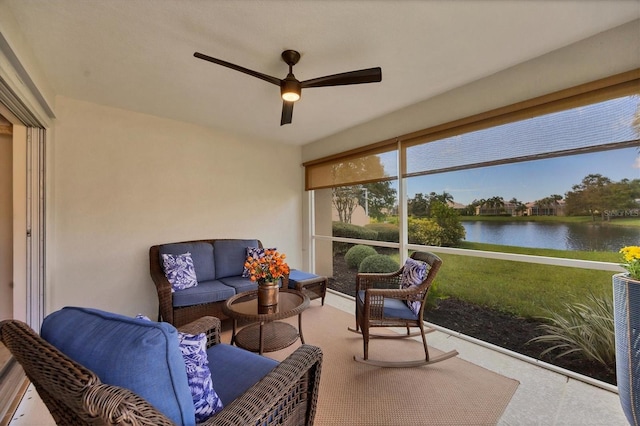 sunroom / solarium with ceiling fan and a water view