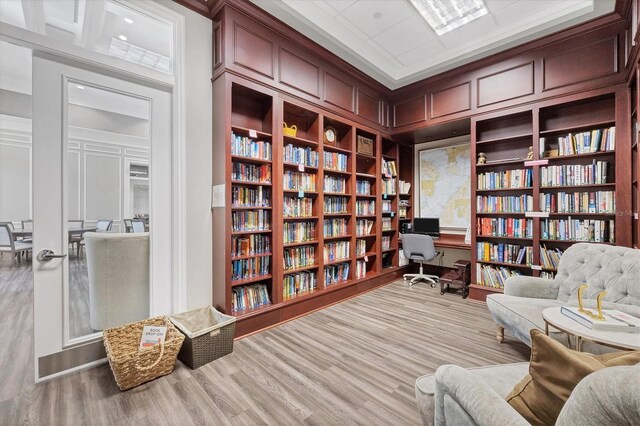 sitting room featuring wood-type flooring and crown molding