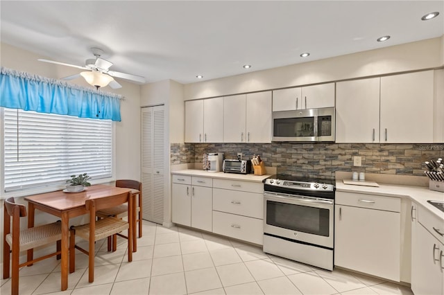 kitchen featuring white cabinets, appliances with stainless steel finishes, and tasteful backsplash