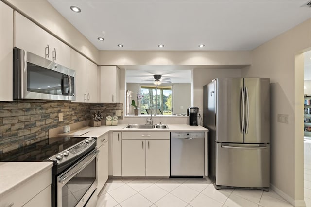 kitchen with ceiling fan, sink, decorative backsplash, light tile patterned flooring, and appliances with stainless steel finishes