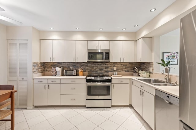 kitchen featuring decorative backsplash, light tile patterned floors, sink, and appliances with stainless steel finishes