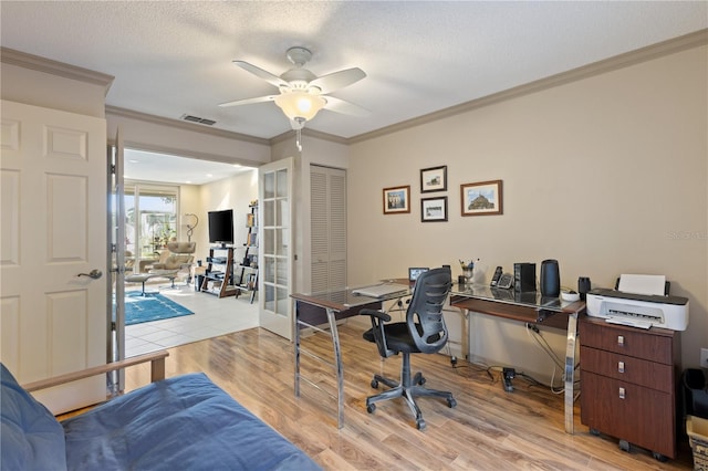 office area featuring ceiling fan, french doors, light hardwood / wood-style flooring, a textured ceiling, and ornamental molding