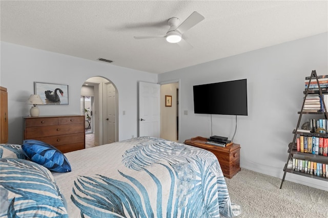 bedroom with light carpet, a textured ceiling, and ceiling fan