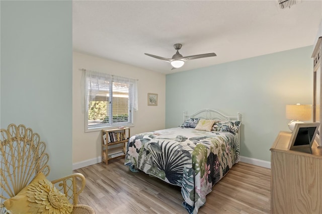 bedroom with light hardwood / wood-style floors and ceiling fan