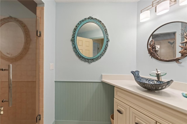 bathroom with a shower with door and vanity