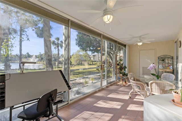 sunroom featuring a water view, a wealth of natural light, and ceiling fan