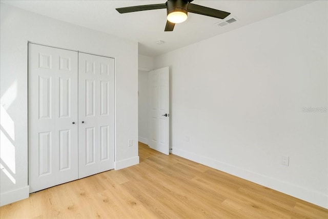 unfurnished bedroom featuring light wood-type flooring, a closet, and ceiling fan