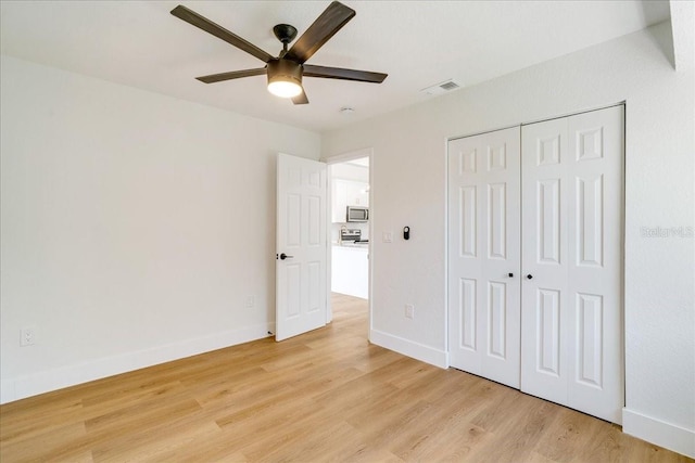 unfurnished bedroom featuring a closet, light hardwood / wood-style floors, and ceiling fan