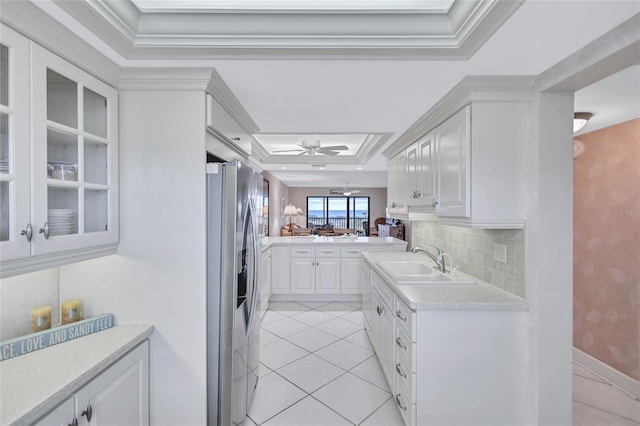 kitchen featuring stainless steel refrigerator with ice dispenser, a tray ceiling, white cabinetry, and sink