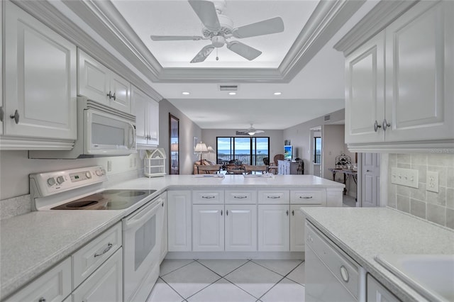 kitchen featuring kitchen peninsula, light tile patterned floors, white appliances, and white cabinetry