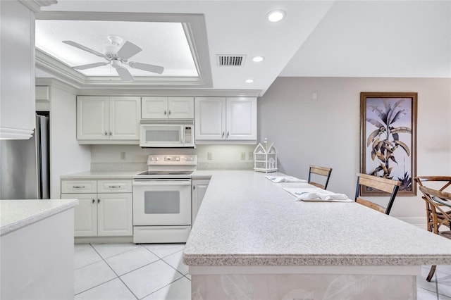 kitchen featuring ceiling fan, white cabinetry, light tile patterned flooring, and white appliances