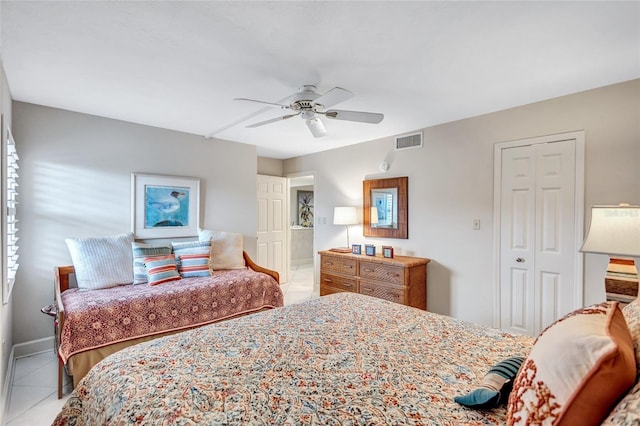 bedroom featuring ceiling fan, light tile patterned flooring, and a closet