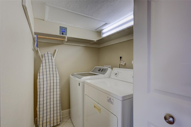 clothes washing area with independent washer and dryer and light tile patterned floors