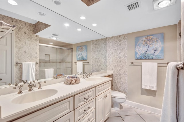 bathroom with toilet, tile patterned flooring, vanity, and walk in shower