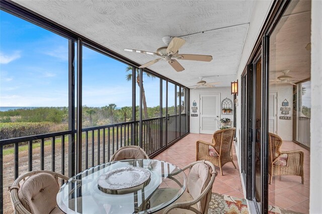 sunroom / solarium featuring ceiling fan