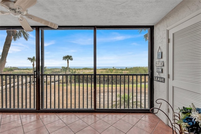 unfurnished sunroom with ceiling fan