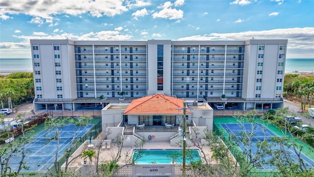 view of property with a community pool and a water view