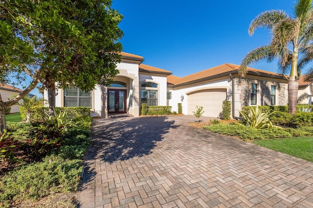 mediterranean / spanish house featuring a garage and french doors