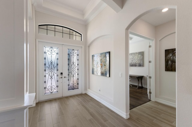 foyer entrance featuring french doors, light wood-type flooring, and ornamental molding