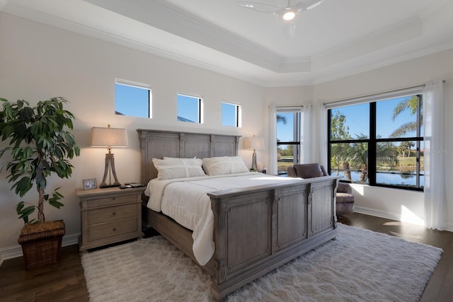 bedroom featuring ceiling fan, crown molding, a water view, and dark wood-type flooring