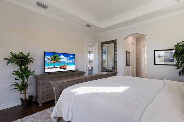 bedroom with dark hardwood / wood-style floors, a raised ceiling, and crown molding