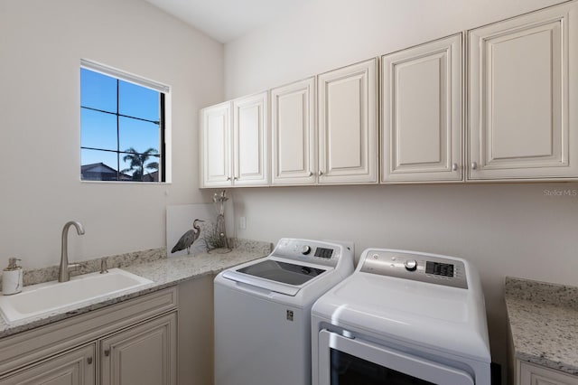 washroom featuring cabinets, independent washer and dryer, and sink