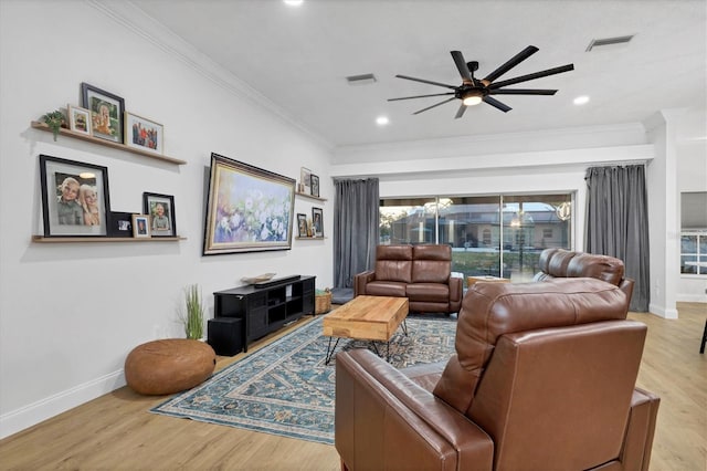 living room with ceiling fan, ornamental molding, and light wood-type flooring