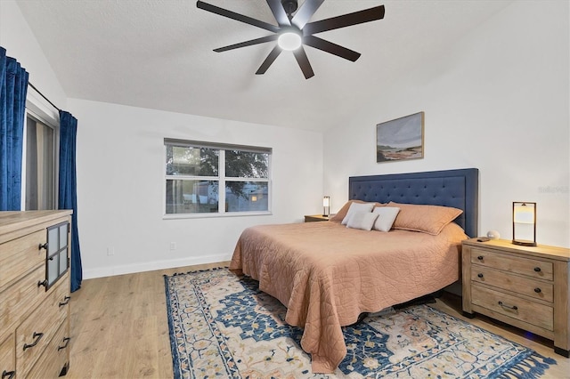 bedroom featuring light wood-type flooring, ceiling fan, and lofted ceiling