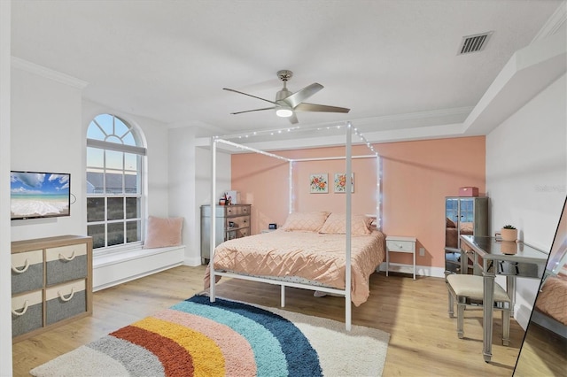 bedroom featuring ceiling fan, crown molding, and light wood-type flooring