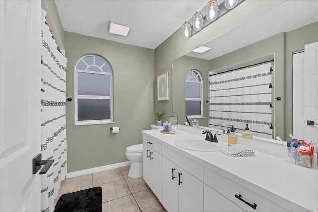 bathroom featuring tile patterned flooring, vanity, a textured ceiling, and toilet