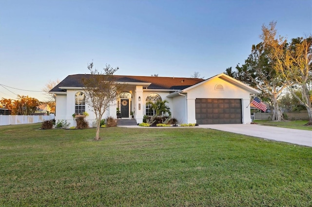 single story home featuring a garage and a front lawn