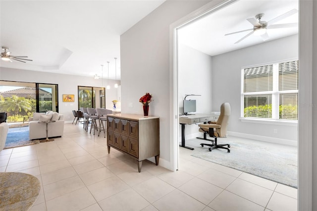 interior space featuring light tile patterned floors, ceiling fan, and baseboards