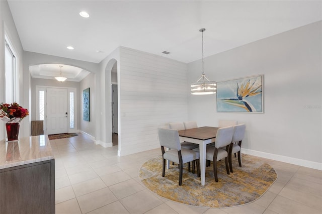 dining space featuring an inviting chandelier, visible vents, arched walkways, and light tile patterned flooring