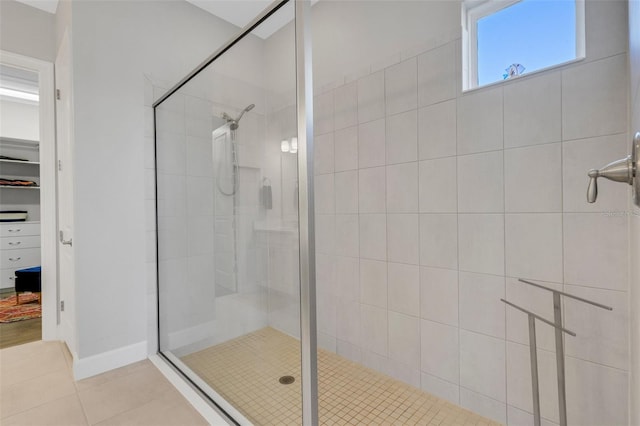 bathroom featuring a stall shower, tile patterned flooring, and a walk in closet