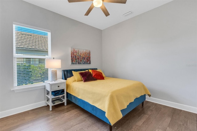 bedroom with visible vents, baseboards, and wood finished floors